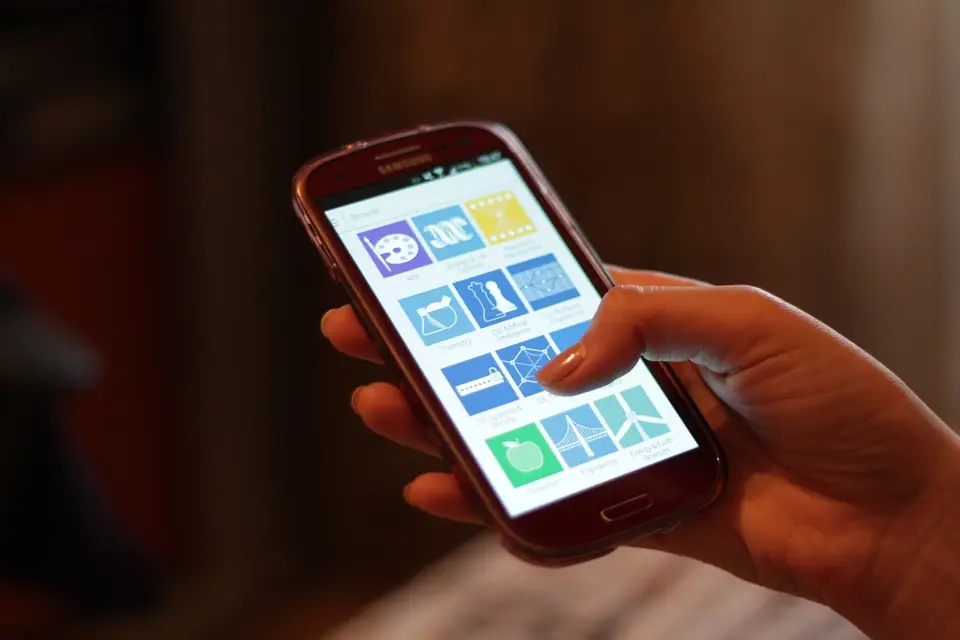 Bir elde tutulan, ekranında uygulama simgeleri bulunan akıllı telefon